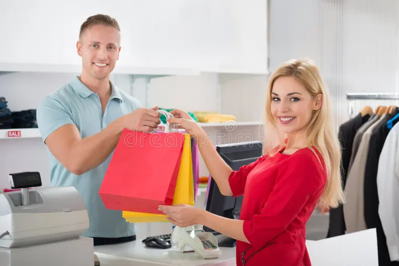 happy customer taking shopping bags salesman store portrait female counter 73407786
